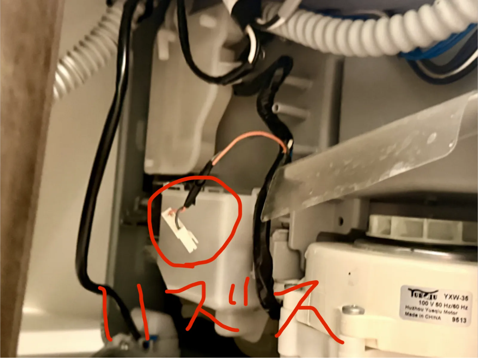 赤丸で囲まれた白い2極のカプラー。すぐ右に排水ポンプのモーター(YXW-35、100V 50/60Hz)が並んでいる