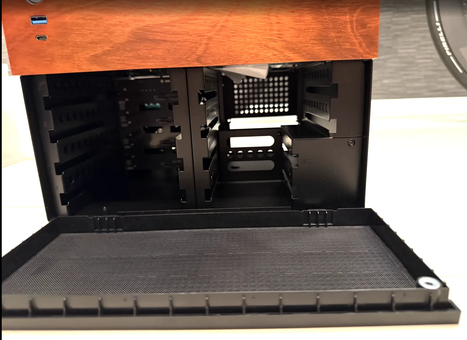 JONSBO N4 のフロントパネルを開けた状態。HDD ベイのケージと底面のダストフィルター