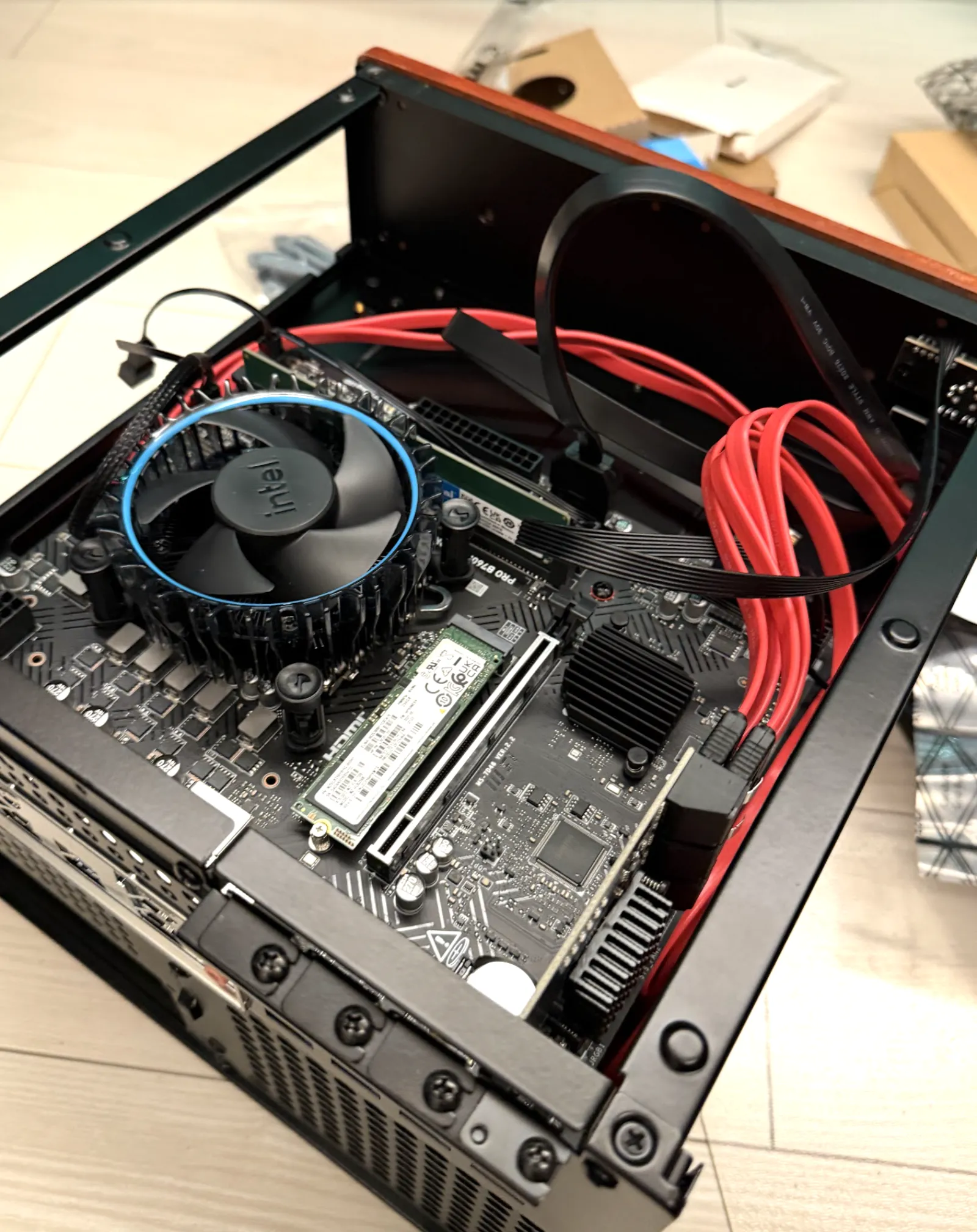 JONSBO N4 のケース内にマザーボードを組み込んだ状態。Intel のリテールクーラーと赤い SATA ケーブルの束