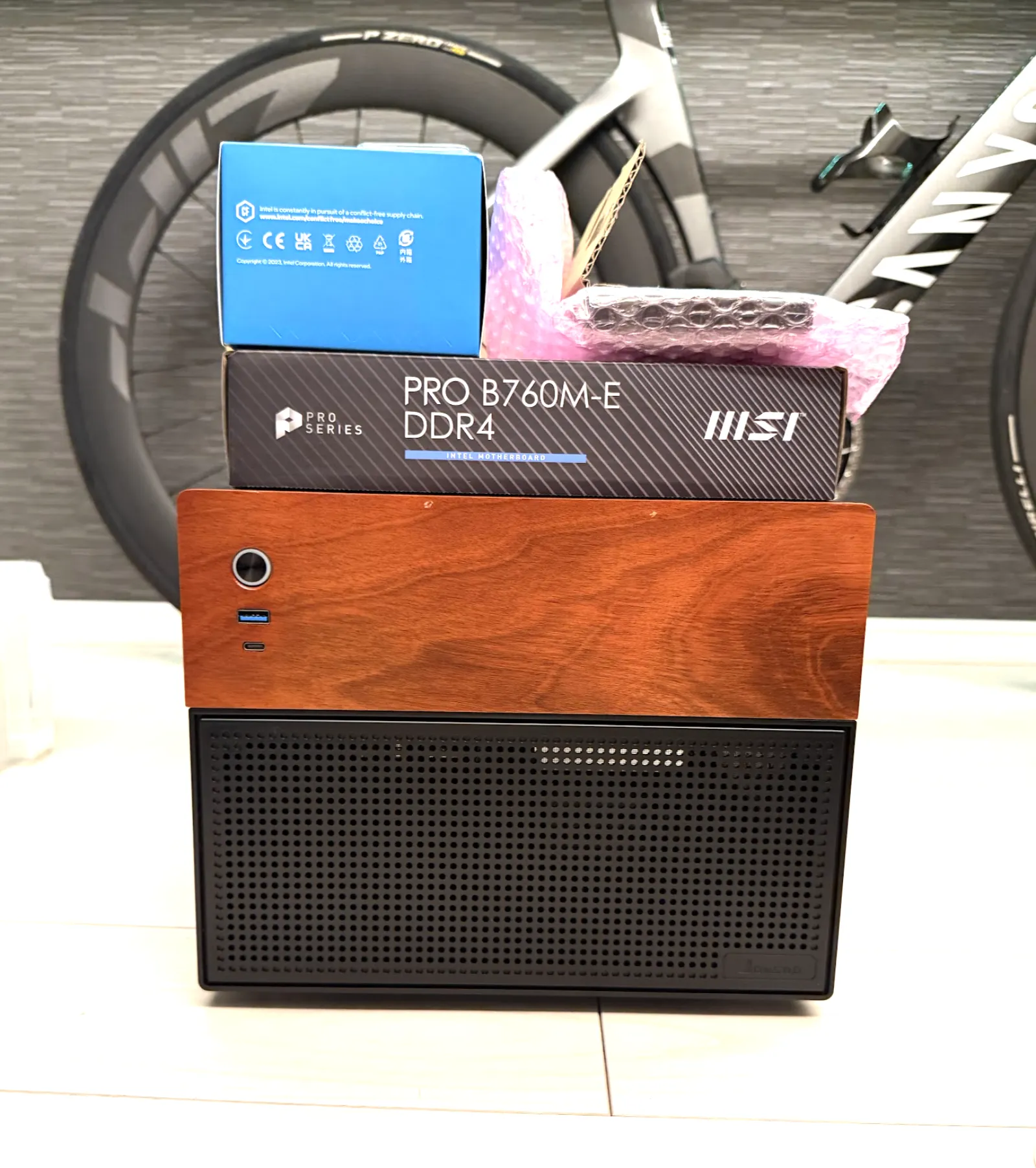 JONSBO N4 のケースの上に MSI PRO B760M-E DDR4 の箱と Intel CPU の箱を積んだ状態